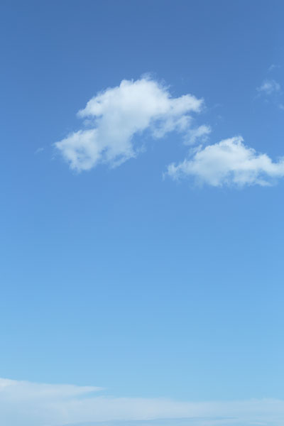 淡い青空に浮かぶのどかな浮き雲。無料画像