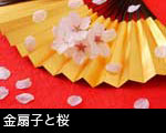 桜の花と花びら 金の扇子 赤い和紙の背景