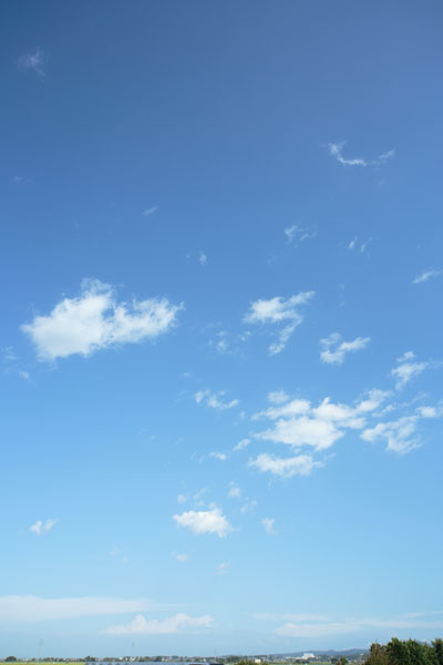 明るい爽やかな青空に点在する雲。空のバックグラウンド・素材。縦位置の画像2枚。